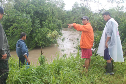 Community members assess the flooding in Quezon, Isabela, after Super Typhoon Lando dumped heavy rains in the area. assessing flooding